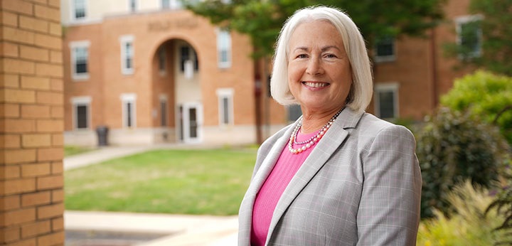 President Clark, 8th President of LRU standing in front of Magdelen Chapel in the foreground with Bold Hall in the background.