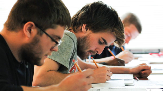 Students writing notes during class at La Roche University.