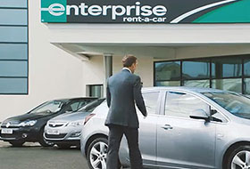 Man walking toward a car at an Enterprise dealership