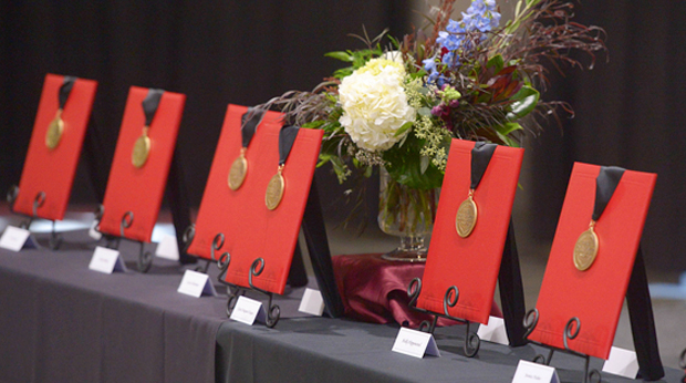 La Roche University award medals displayed on a table with a flower centerpiece.