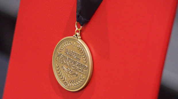 A La Roche University Distinguished Alumni Circle award medal hangs on a red display.