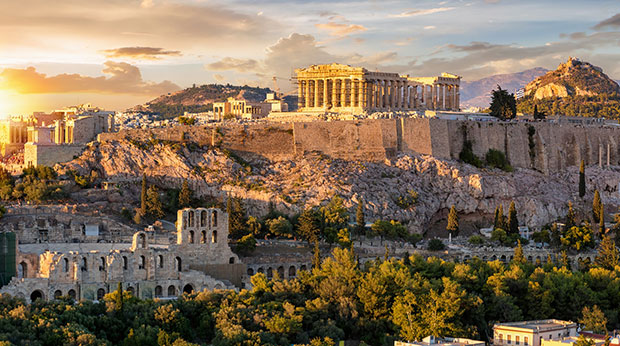 The Acropolis of Athens, Greece, with the Parthenon Temple on a hill during a summer sunset.