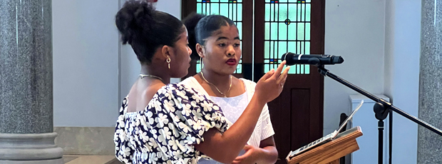 Two female Black students singing at Convocation