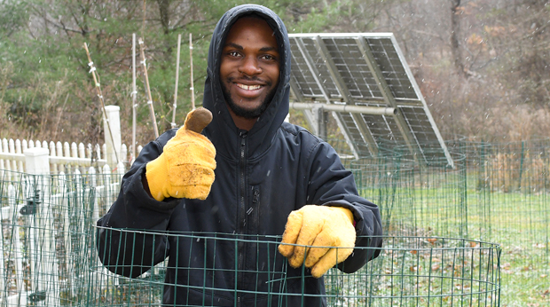 A La Roche University student does yard work for Day of Service.