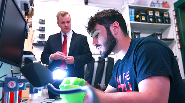 A criminal justice student examine evidence under a light in the crime scene investigation lab at La Roche University.