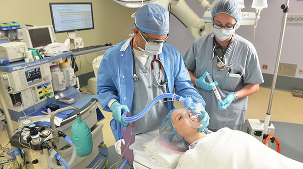 Two anesthesiologists working on a patient in an operating room.
