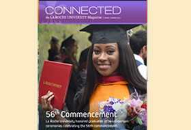 The Spring 2022 cover of the La Roche magazine. A graduate wearing her cap and gown holds a diploma.