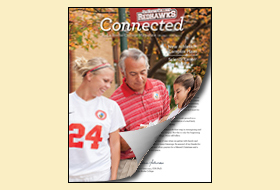 The Spring 2014 cover of the La Roche magazine. The masthead titled Connected appears at the top. The cover photo shows a soccer coach with two students in soccer uniforms outside on a fall day.