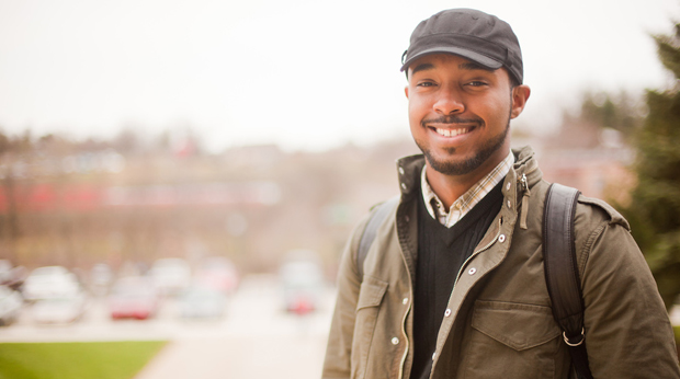 A male student at La Roche University stands in a parking lot on campus.