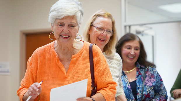 Three members of La Roche University's Adventures in Lifelong Learning stand in line at an event.