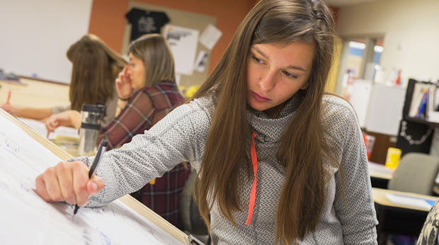 A La Roche University student draws at a drafting table.