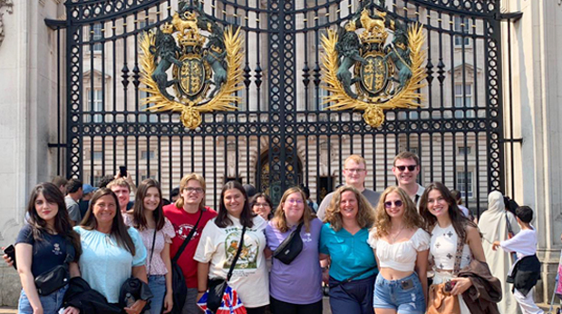 Group of La Roche students standing in front of the ornate gates of Buckingham Palace.