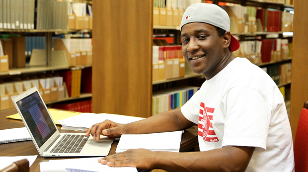A La Roche University student working on his laptop in the Wright Library.