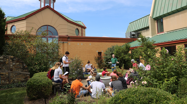 A La Roche University professors holds class outside in front of Magdalen Chapel.