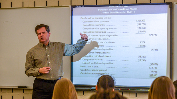 A La Roche University professor stands in front of a Smart Board, teaching a class.