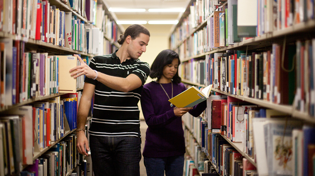 Two students look at books in the Wright Library at La Roche University.