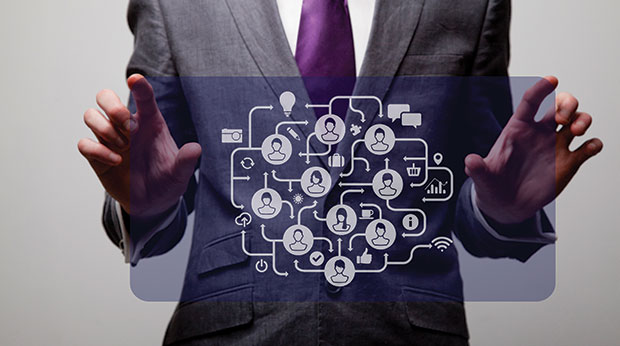 A person in a suit touches a virtual computer screen with multiple icons.