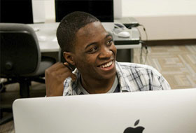 A La Roche University student seated in a computer lab smiling.