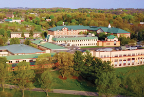 Aerial view of the La Roche University campus surrounded by trees.